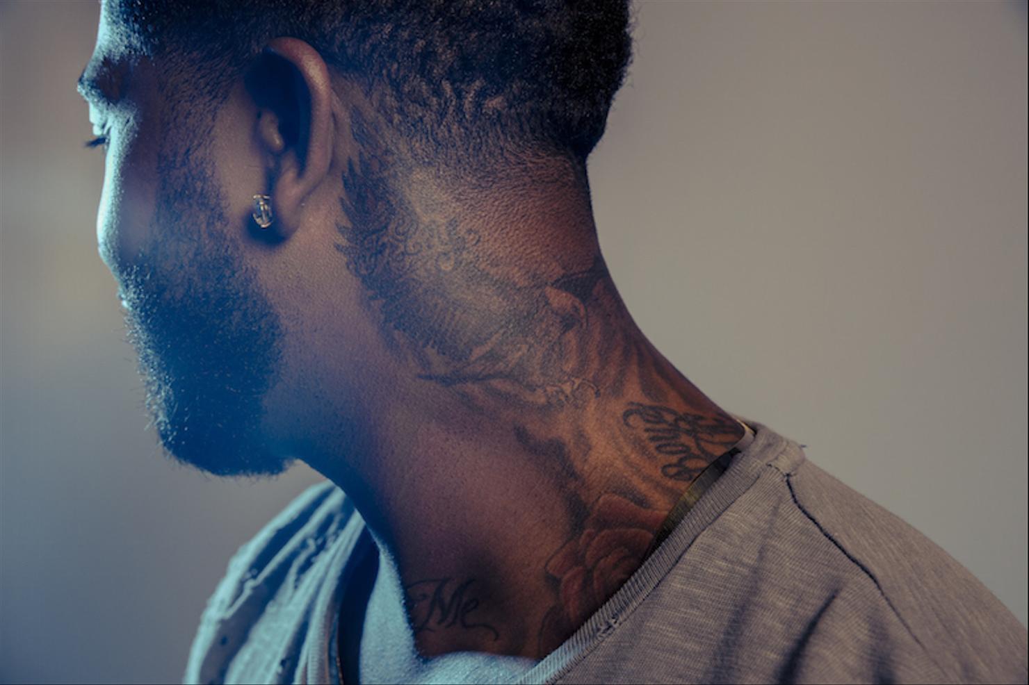 Omarion neck eagle and script tattoo
