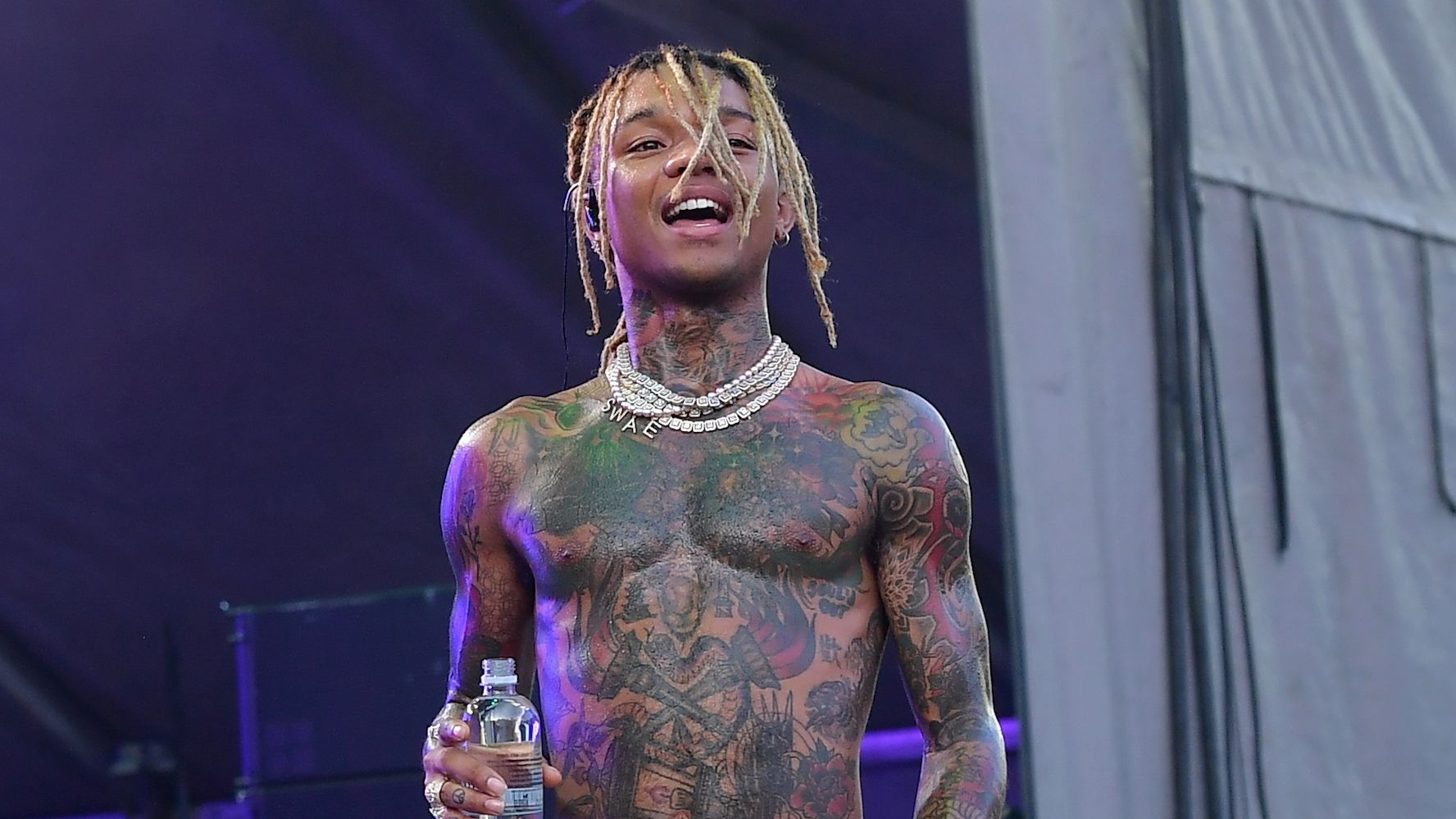 Swae Lee shirtless live portrait showing chest and arm tattoos