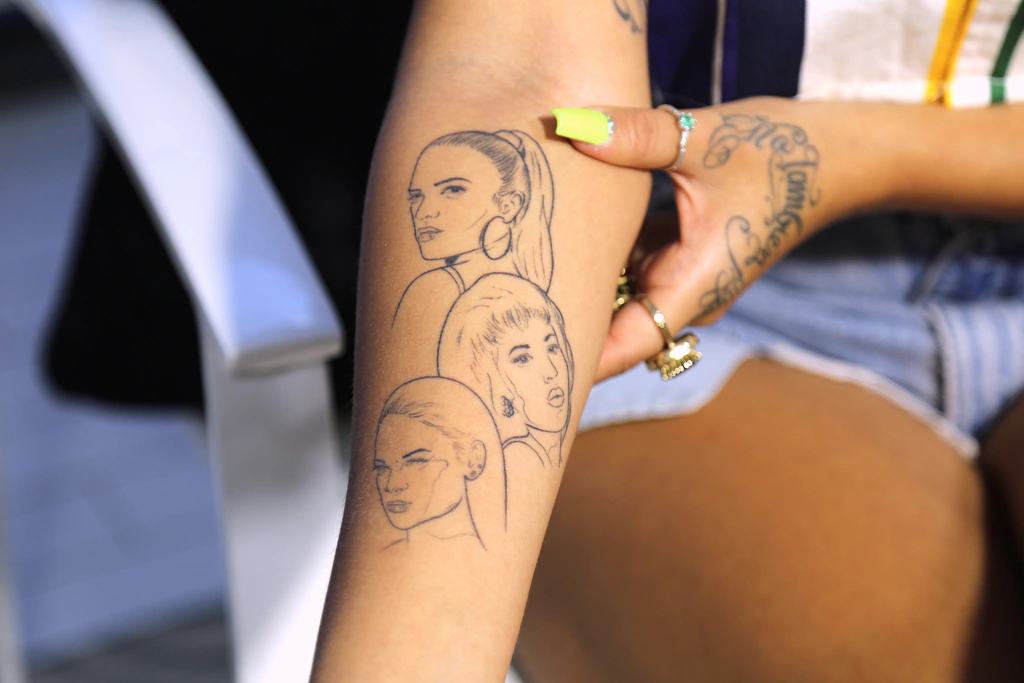 Karol G’s forearm tattoo with portraits of Rihanna, Selena Quintanilla and Karol G