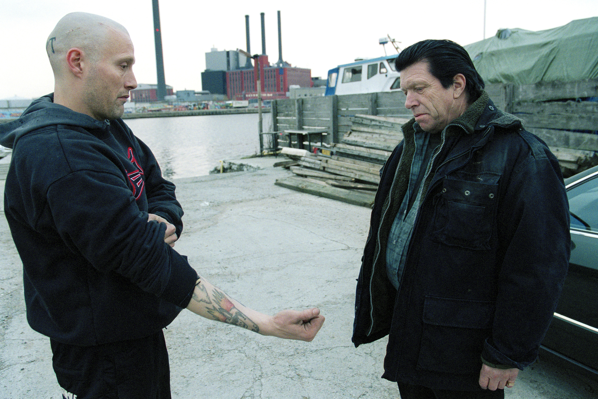 Mads Mikkelsen as Tonny extending his tattooed forearm during a Pusher II scene