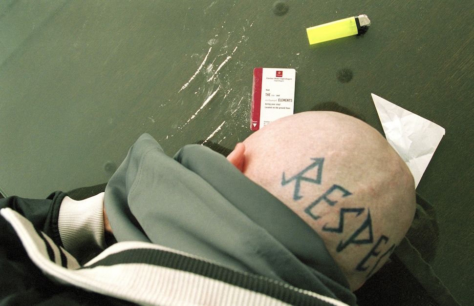 Close view of Mads Mikkelsen as Tonny with the RESPECT tattoo visible on his shaved head