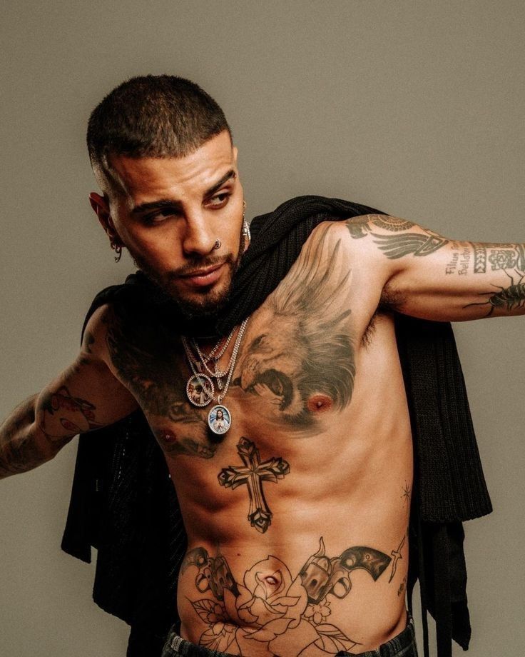 Rauw Alejandro cross and sleeve tattoos