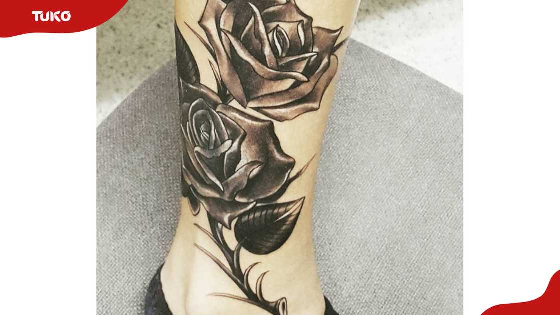 Close view of Karol G’s black rose tattoo on her lower leg