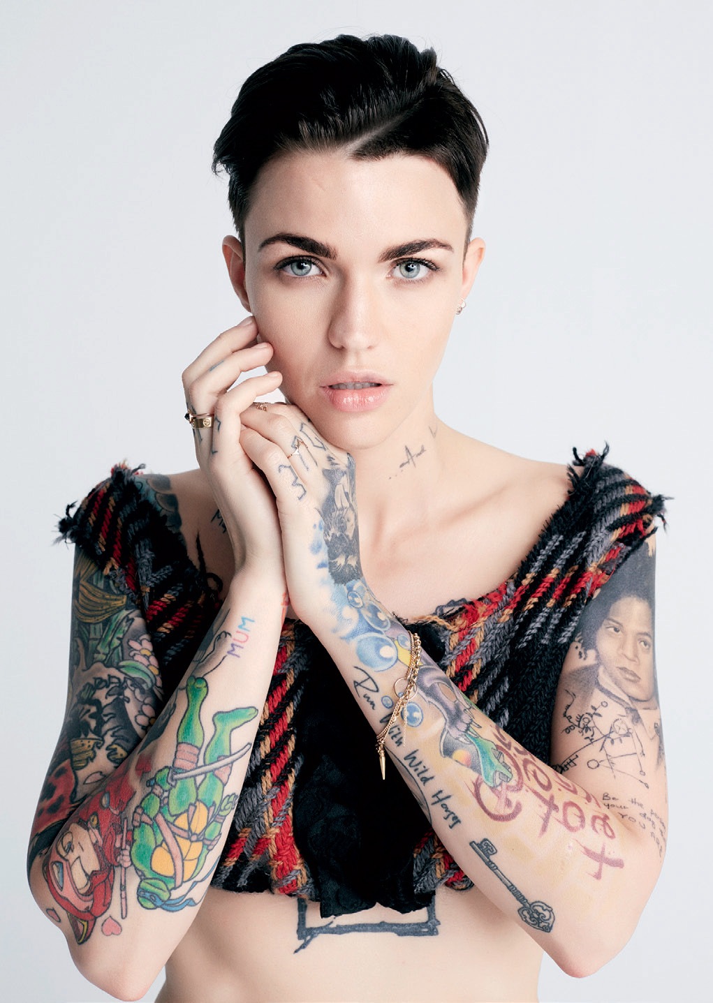Ruby Rose showing both tattoo sleeves with portraits, lettering and colourful designs