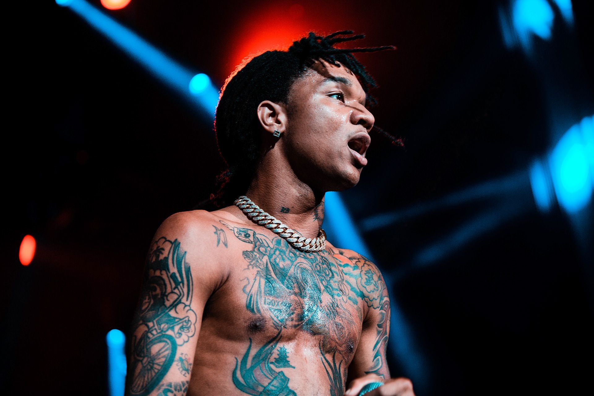 Swae Lee high-resolution stage portrait with visible chest and arm tattoos