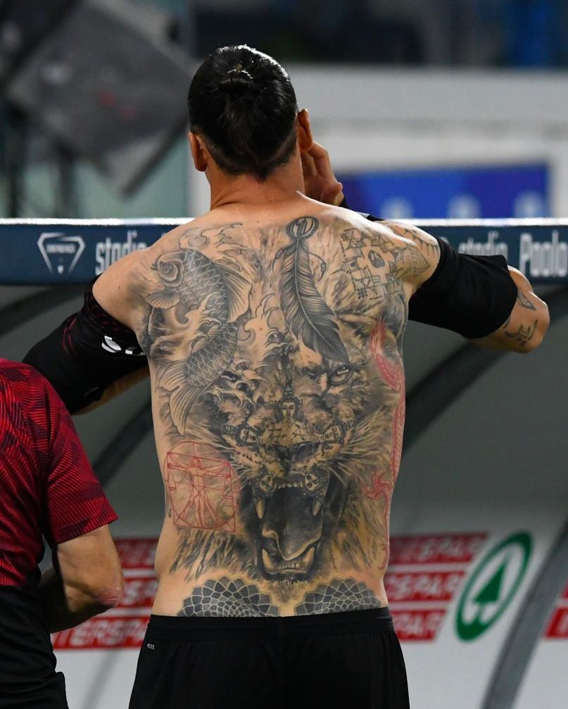 Zlatan Ibrahimovic revealing the large tattoo composition on his back and torso