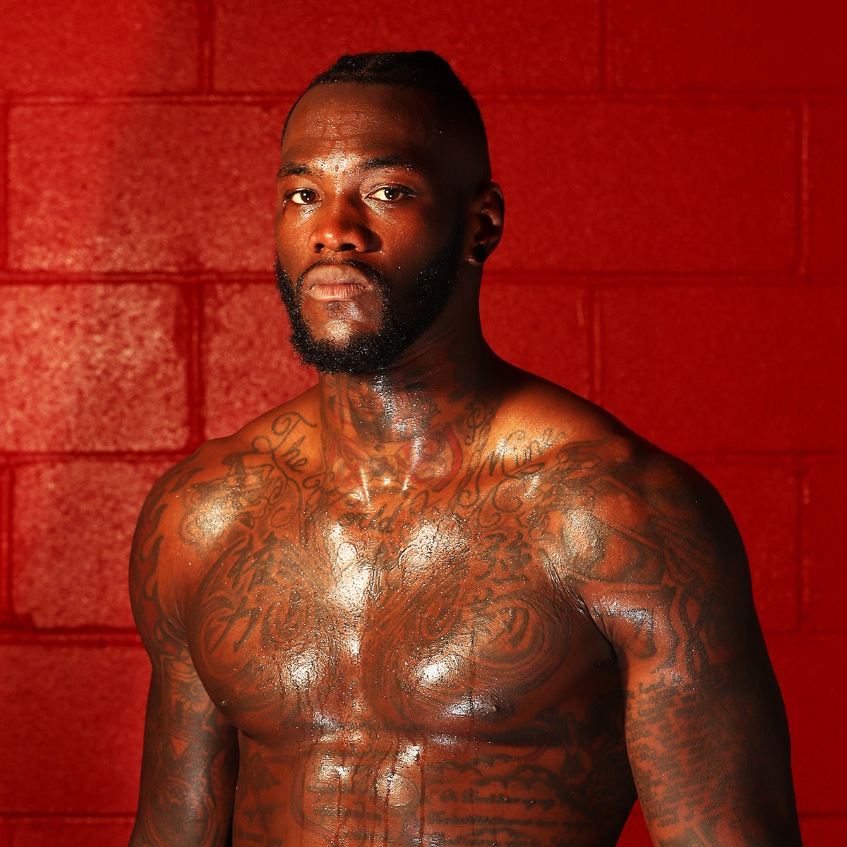 Deontay Wilder tattoos: layered chest tattoos in a close shirtless portrait