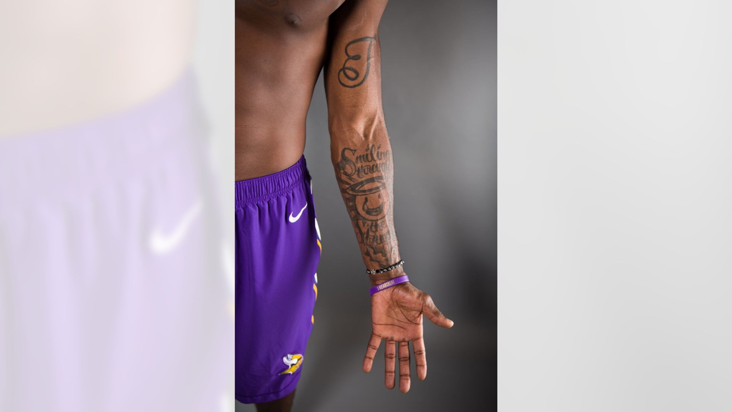 Laquon Treadwell right-arm lettering tattoo portrait Laquon Treadwell tattoos: close color photograph showing right-arm lettering and sleeve tattoos