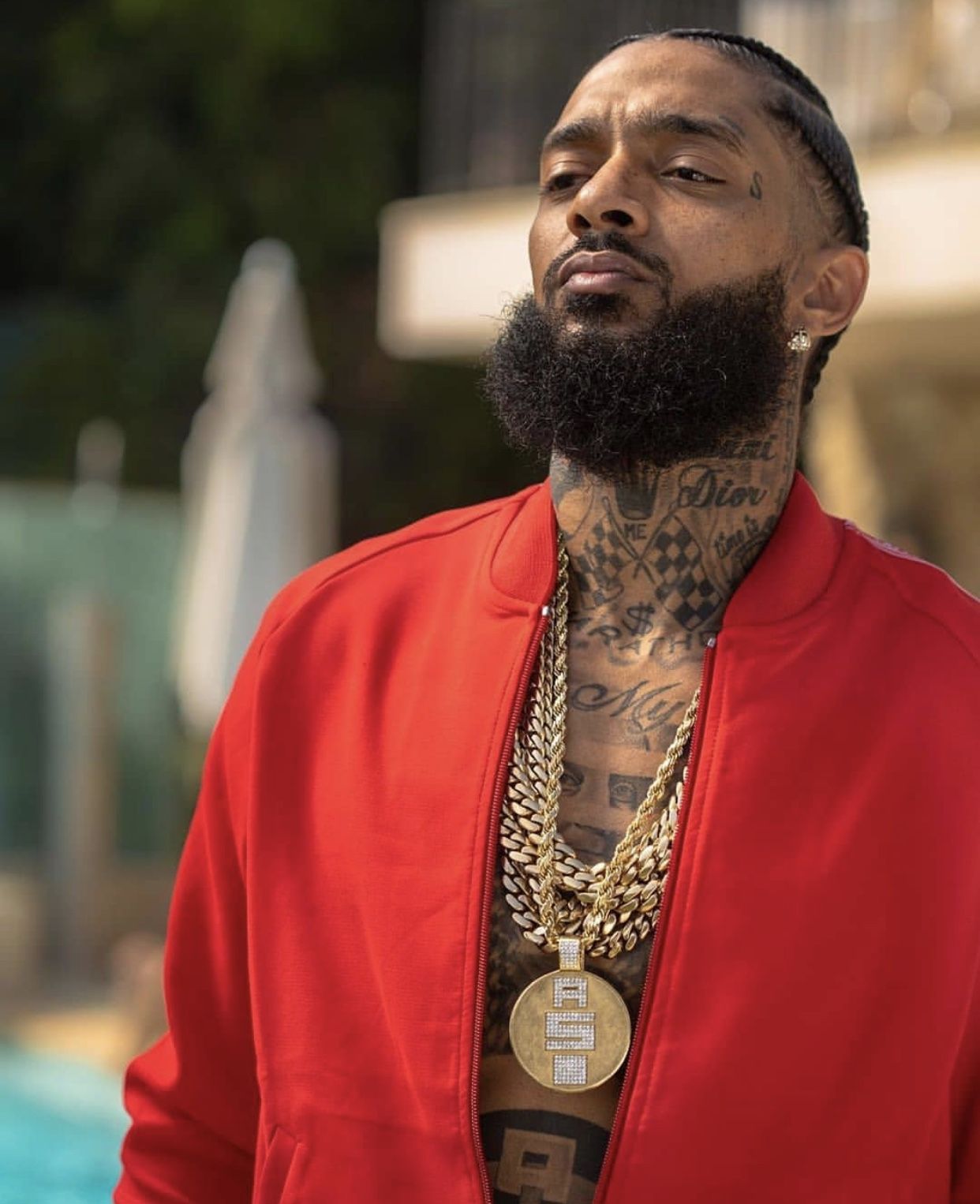 Nipsey Hussle tattoos: tattoo placement with an open jacket