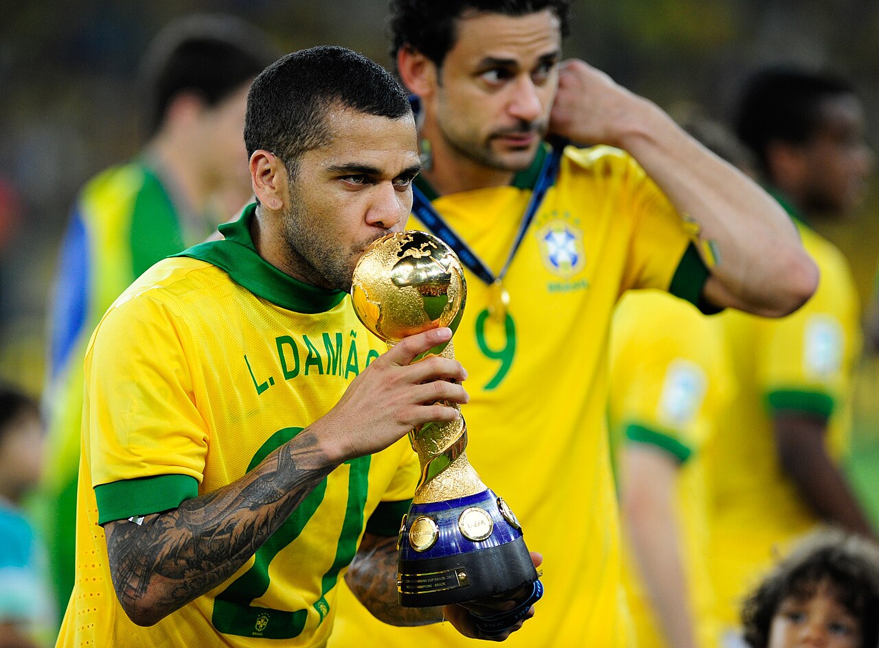 Dani Alves tattoos: clean high-resolution football photograph showing the dense sleeve, hand tattoo and face in a real trophy celebration