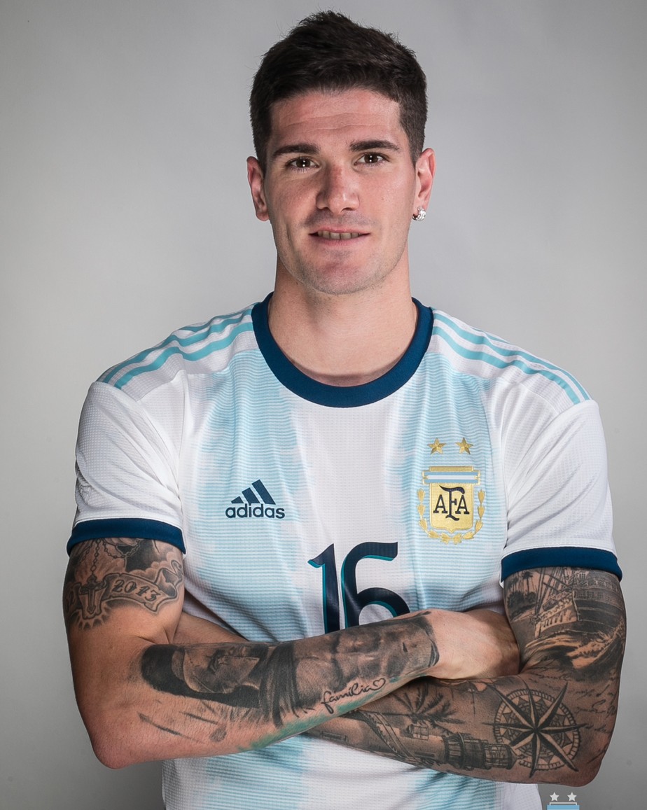 Rodrigo De Paul tattoos: clean face-visible Argentina portrait showing the compass-like chest work, forearm marks and footballer context