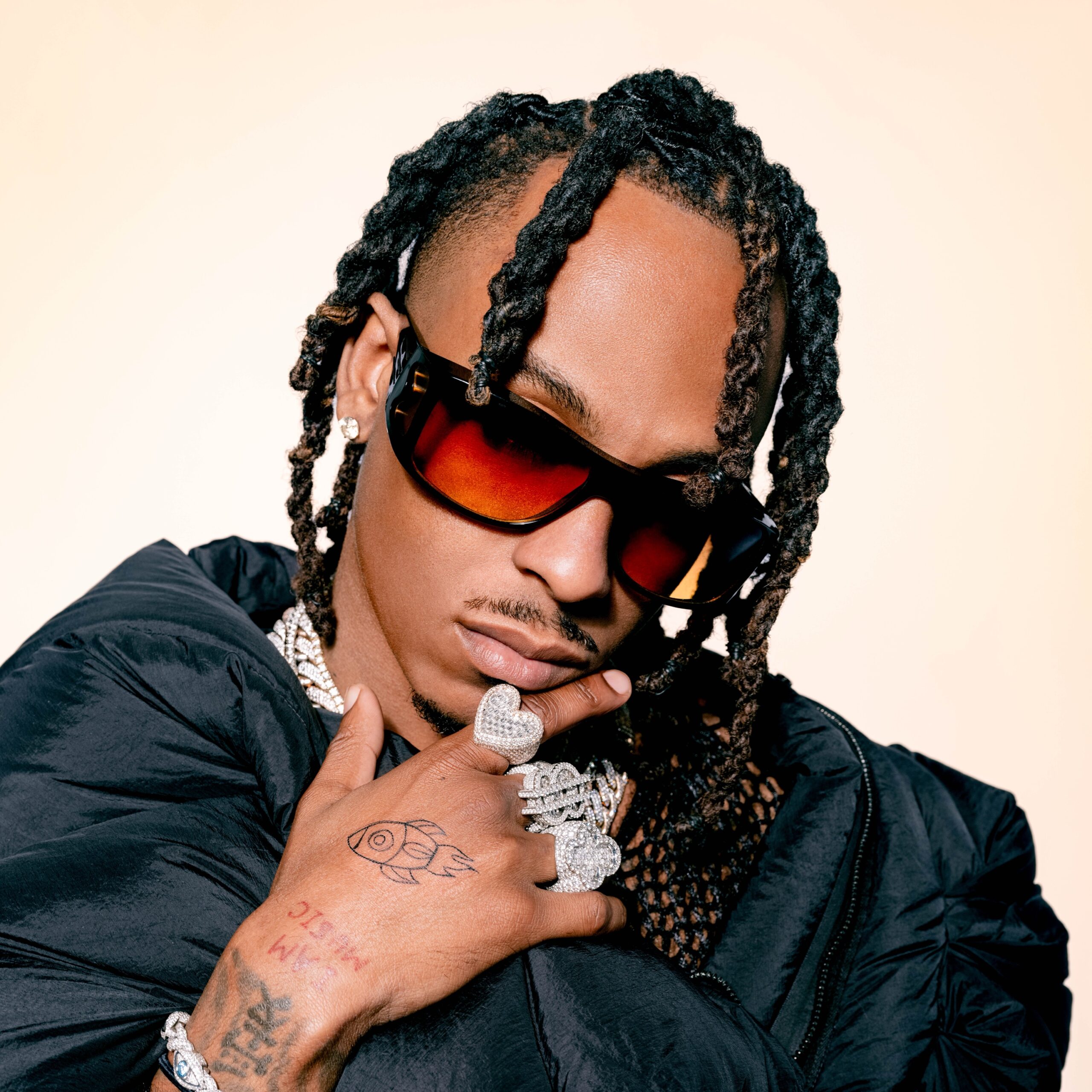 Rich The Kid tattoos: hand tattoo and wrist details beside oversized rings