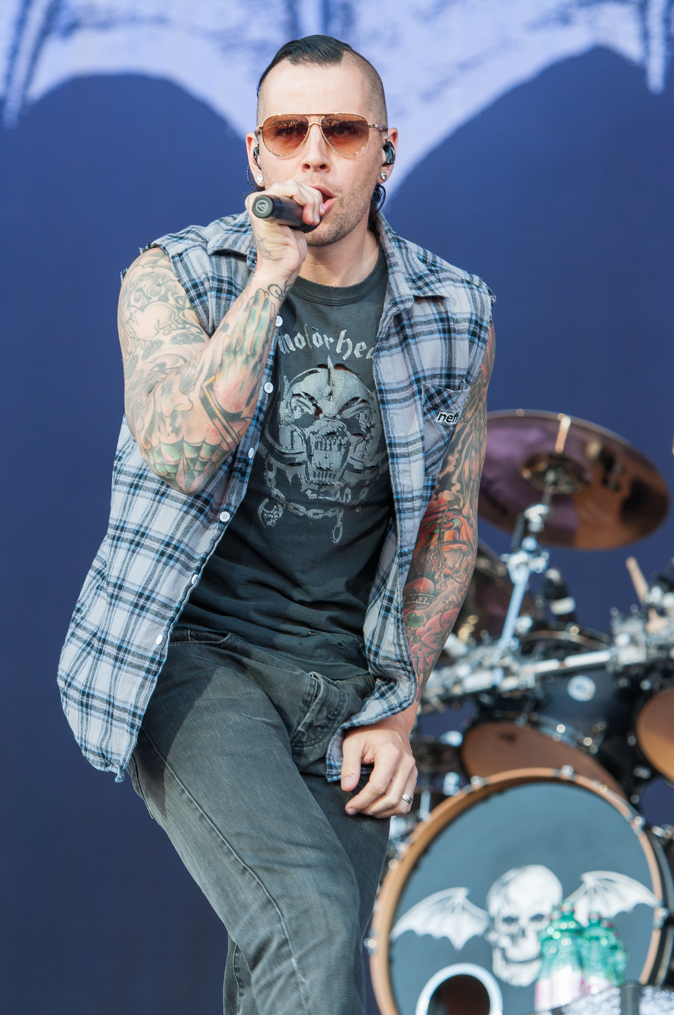 M. Shadows showing his tattooed arms on stage