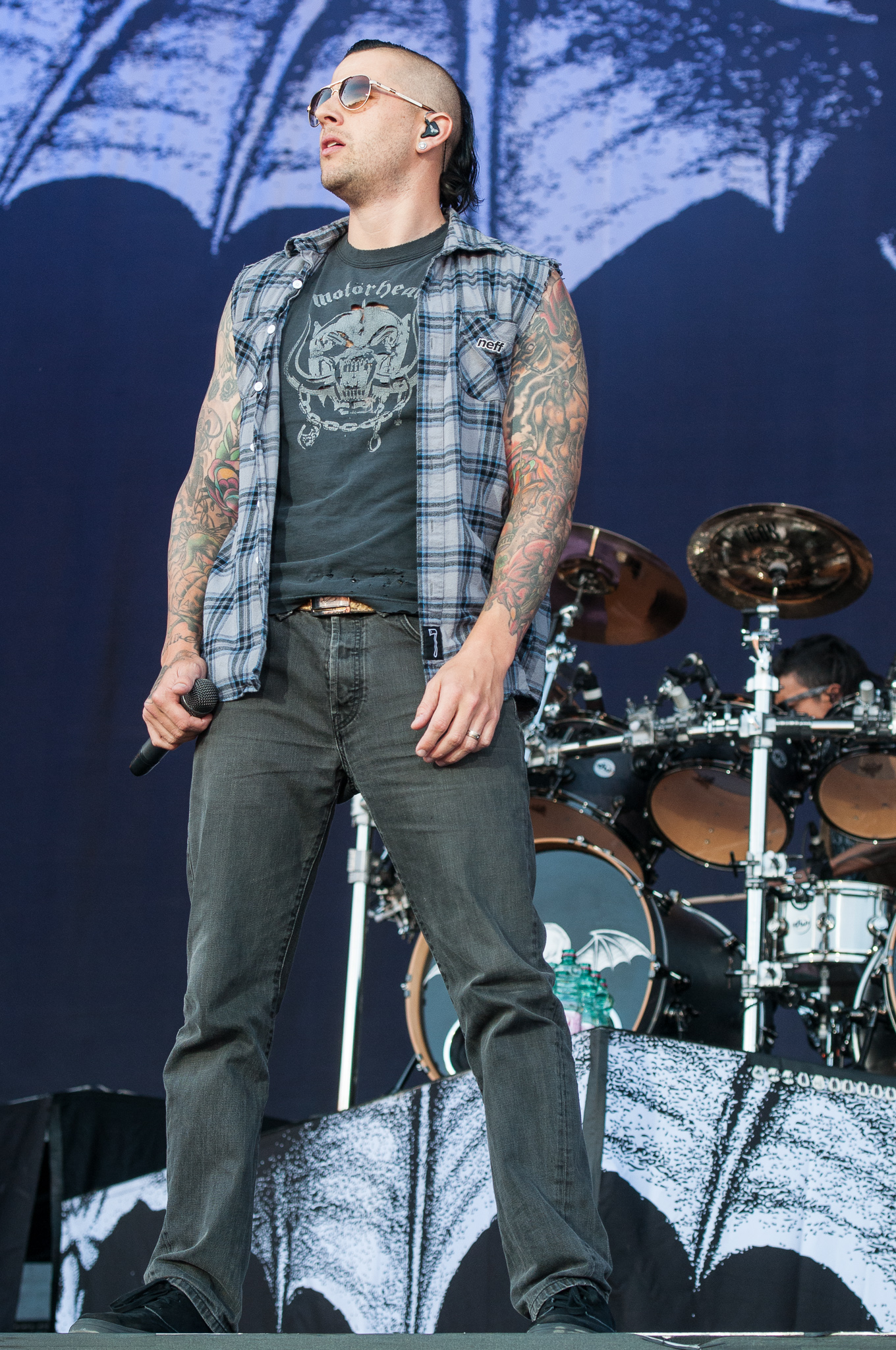 M. Shadows standing on stage with both tattoo sleeves visible
