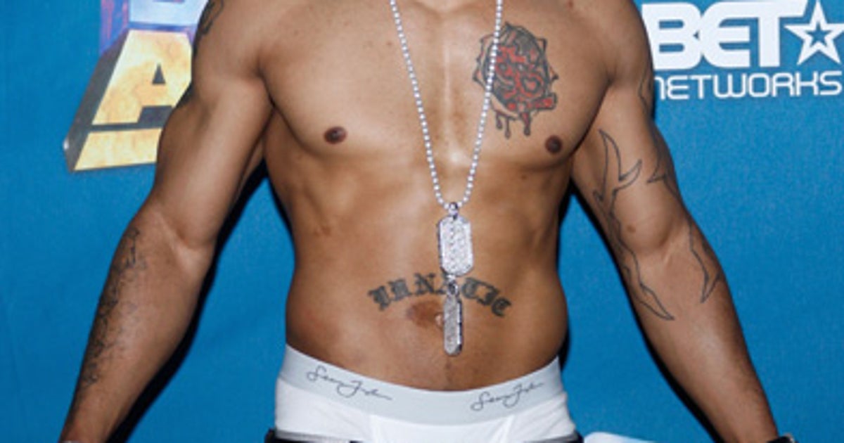 Nelly tattoos: event portrait showing both arms, the chest piece and the waistband lettering together