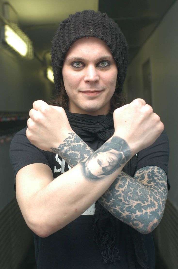 Ville Valo tattoos: wide portrait showing both forearms, a visible face and the sleeve silhouette together