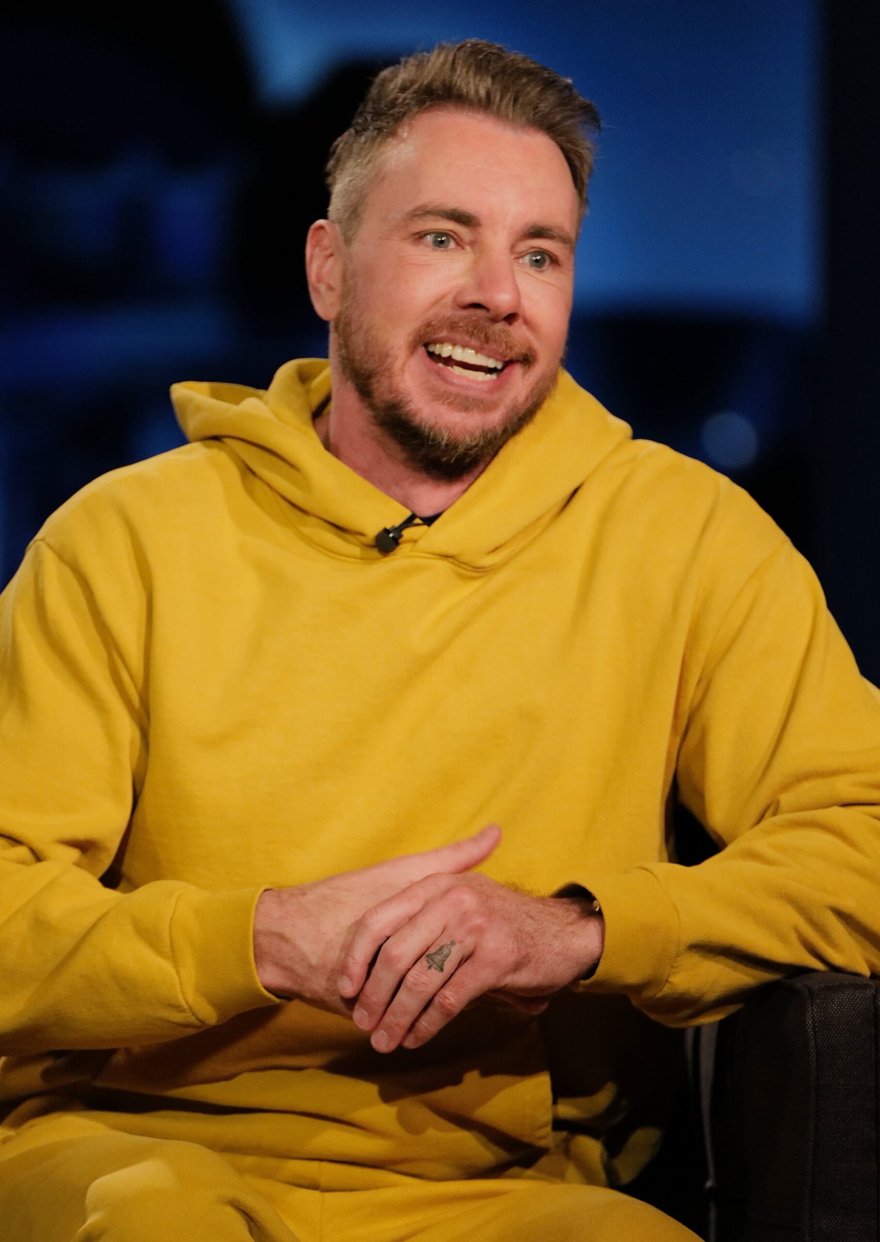 Dax Shepard tattoos: separate high-resolution photograph showing the hand, ring-finger bell and the tattoo's scale in a wider pose