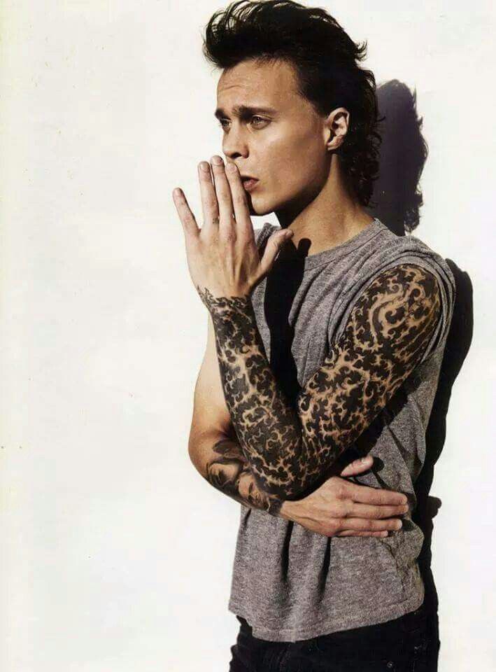 Ville Valo tattoos: face-visible studio portrait exposing the sleeve and small opposite-arm tattoo details