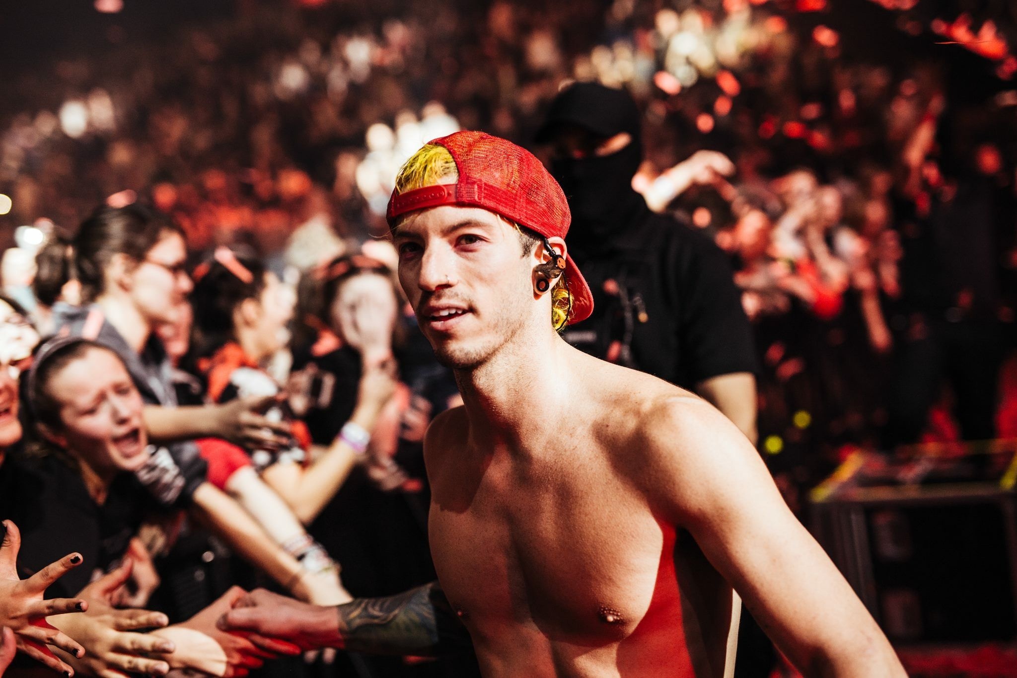 Josh Dun tattoos: wide live shot showing the ink from shoulder to forearm during a masked performance