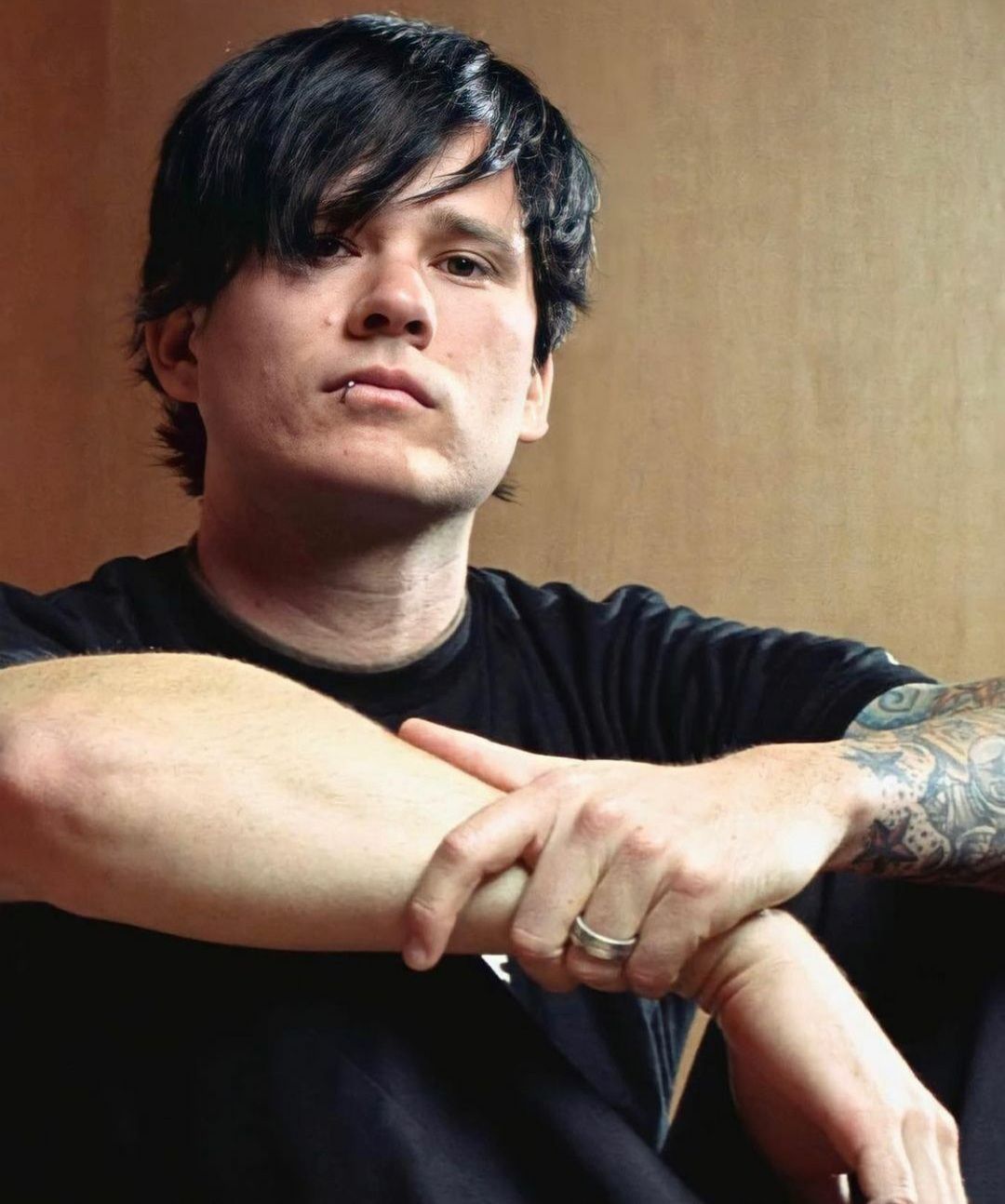 Tom DeLonge tattoos: tight portrait where the colorful forearm panels and black line work sit beside DeLonge's face