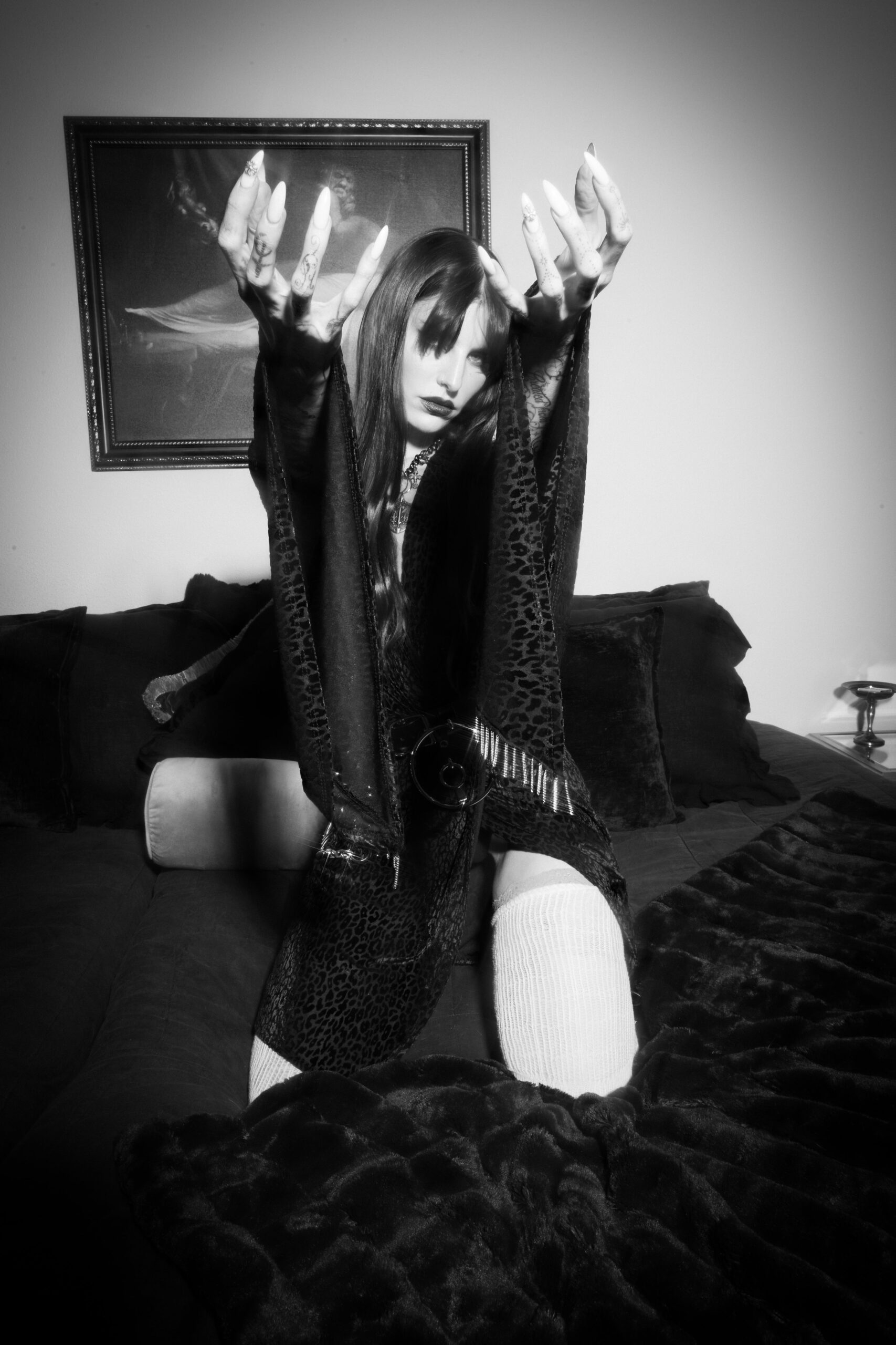 Lilith Czar tattoos: high-resolution black-and-white portrait with the finger, hand and forearm tattoos visible around her face