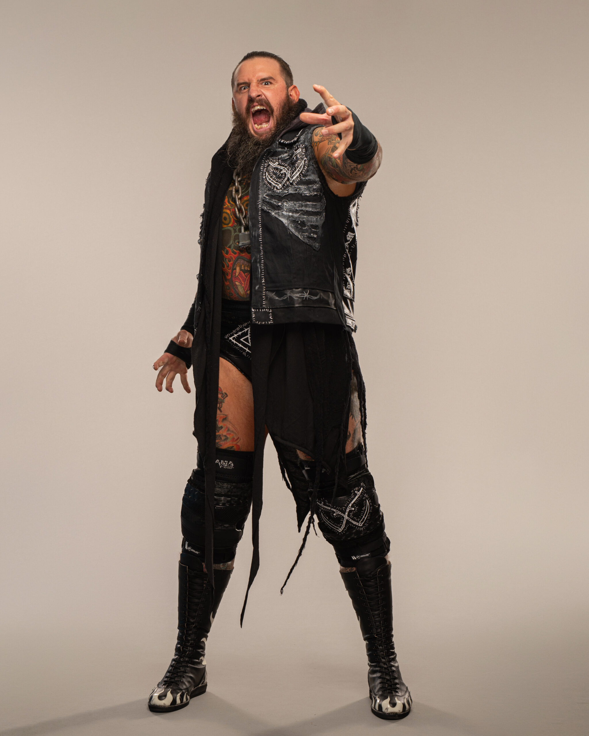 Brody King tattoos: studio-quality photograph showing colourful arm and leg pieces with the face clearly visible while keeping the tattoo work readable