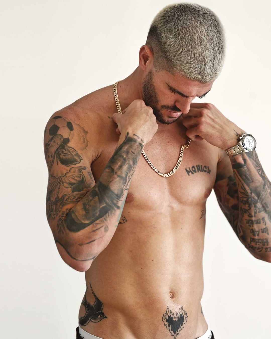 Rodrigo De Paul tattoos: clean studio portrait showing the sleeves, chest lettering, religious details and newer relationship tattoo in full resolution