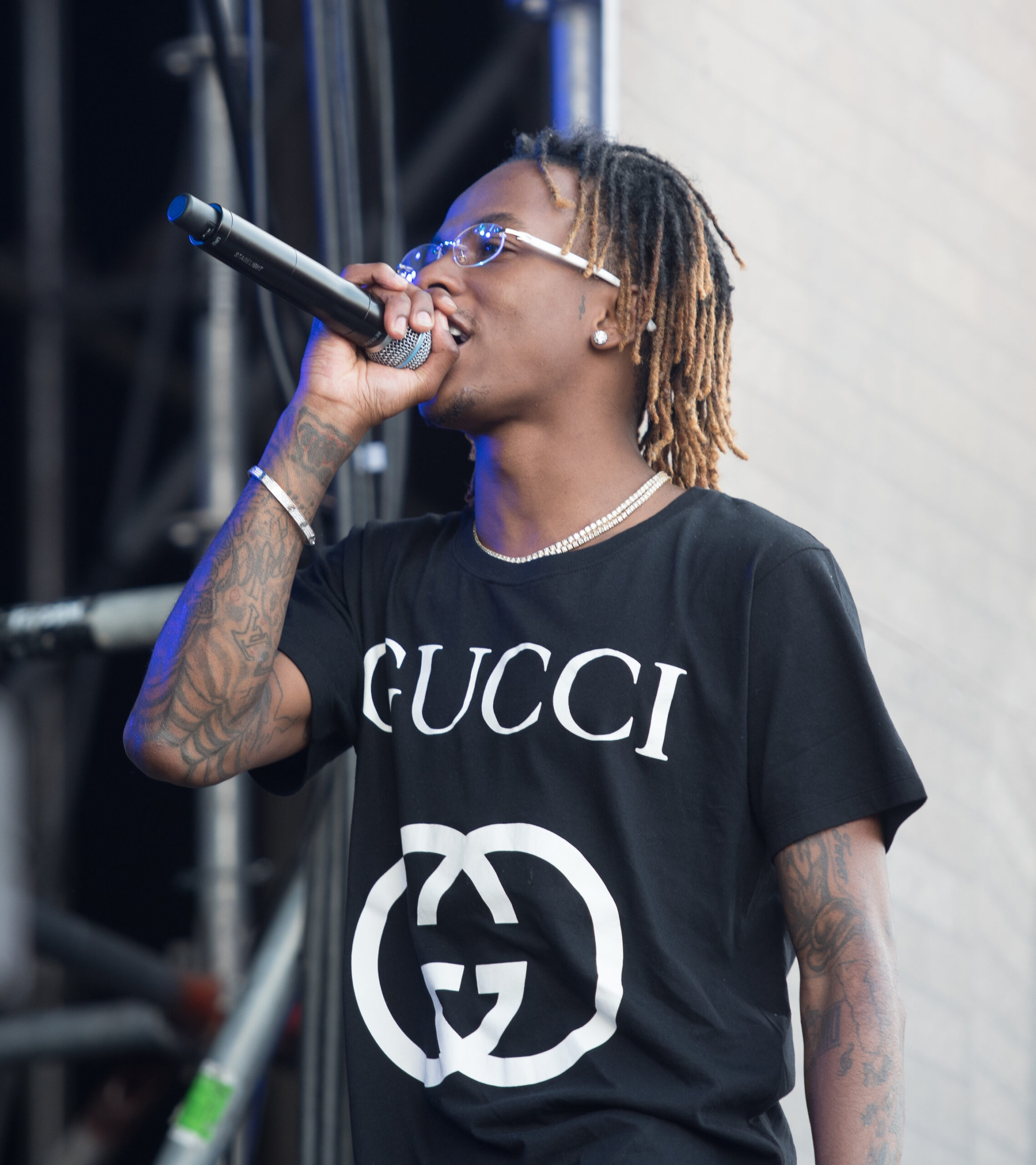 Rich The Kid tattoos: small face detail and exposed arm tattoos onstage