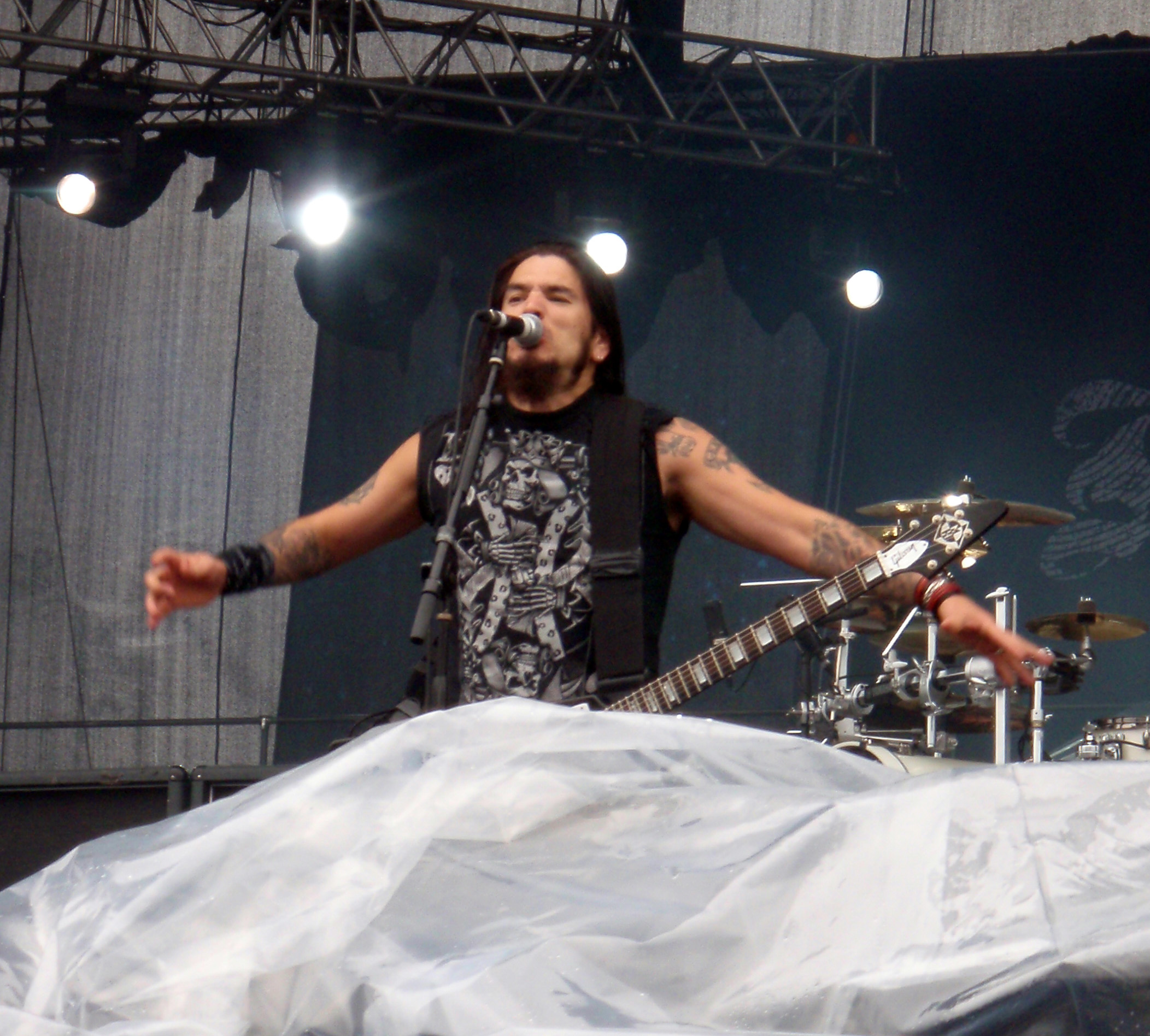 Robb Flynn tattoos: high-resolution stage photograph showing the geometric forearm work, upper-arm colour and layered sleeve coverage