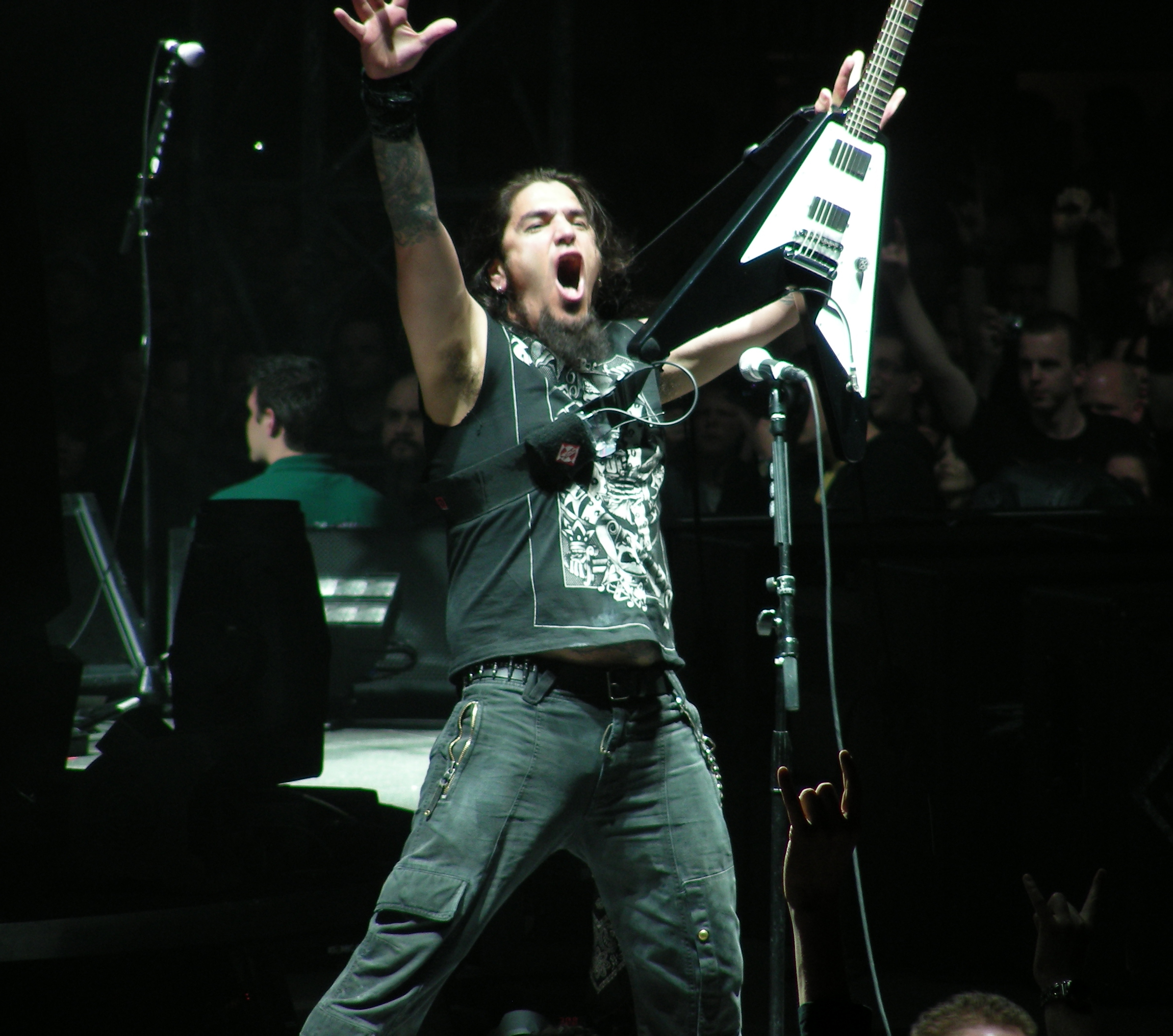 Robb Flynn tattoos: high-resolution live photograph showing the dense upper-arm and forearm tattoos as Flynn raises his guitar