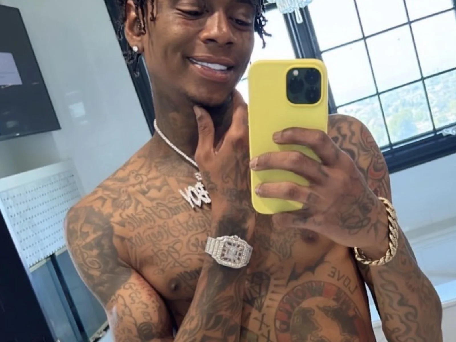 Soulja Boy tattoos: high-resolution mirror photograph showing dense chest, arm, and hand ink