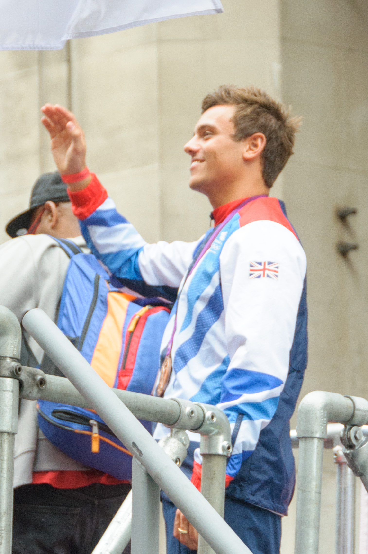 Tom Daley waving to supporters at the London 2012 victory parade