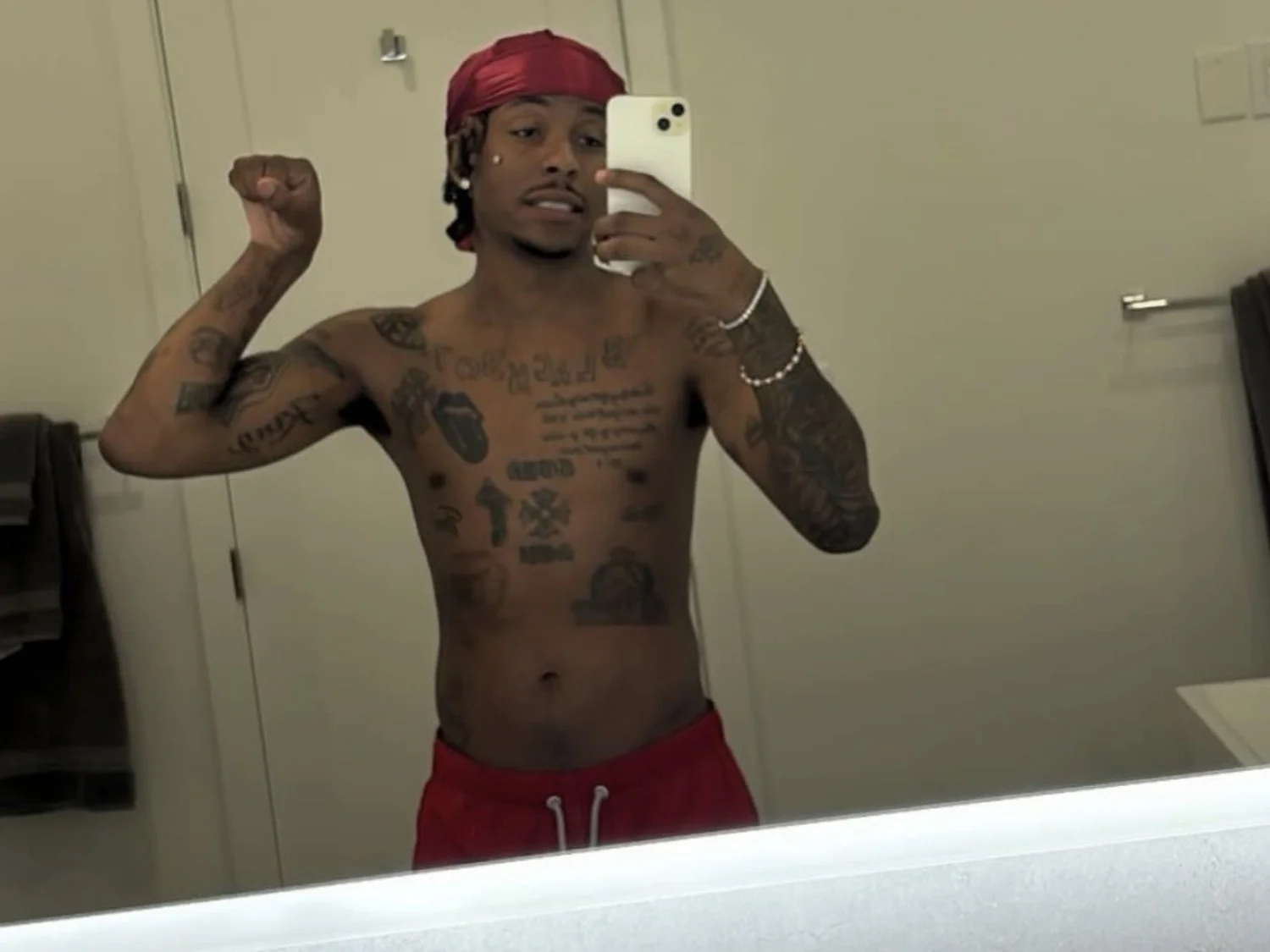 Rich The Kid tattoos: shirtless chest lettering and stacked torso script