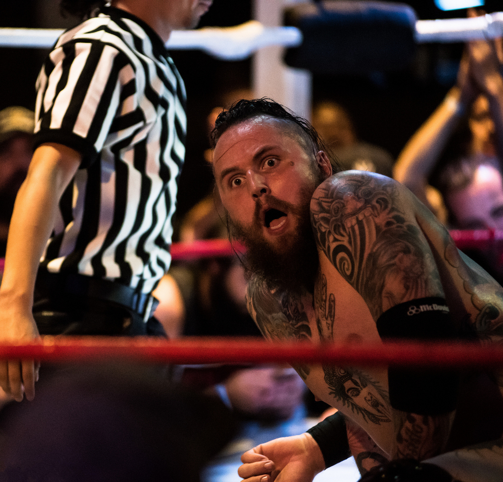 Malakai Black tattoos: clear action photograph showing the shoulder, arm and thigh tattoos around the wrestling gear