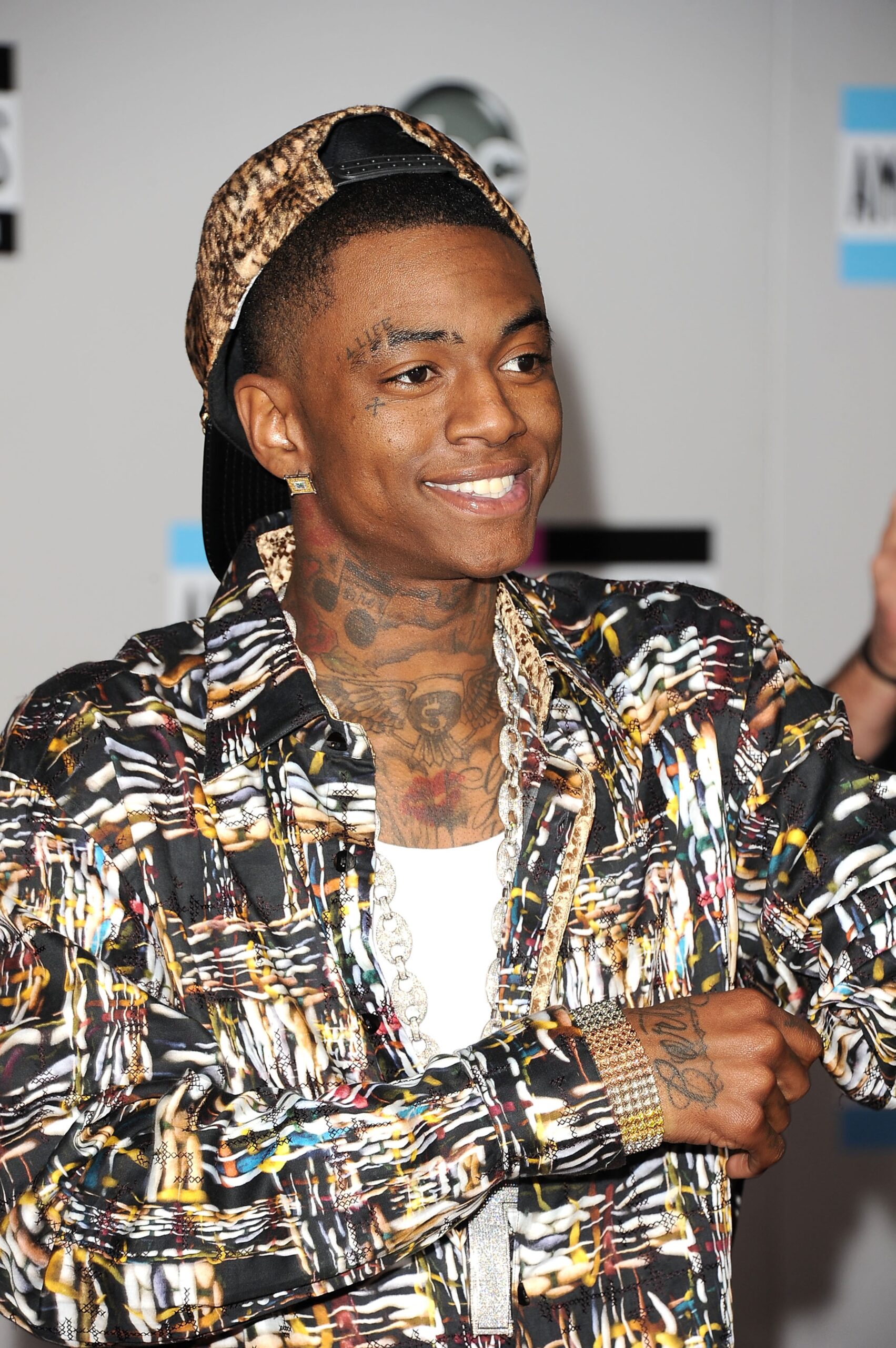 Soulja Boy tattoos: high-resolution event portrait showing the neck piece, chest design, and hand ink