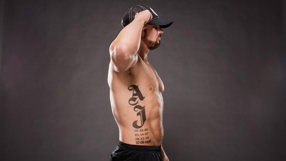 AJ Styles tattoos: inline close view of newest date and pink ribbon