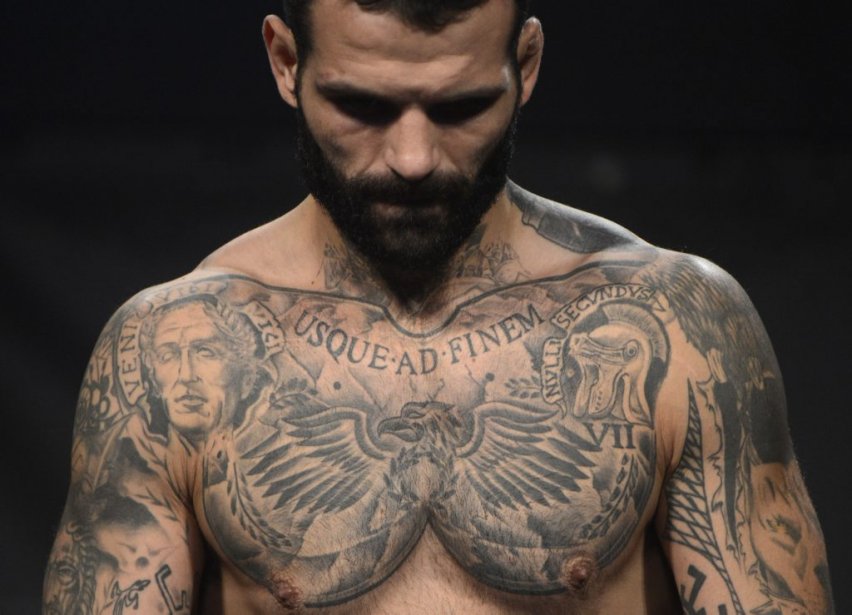 Close view of Alessio Sakara’s chest eagle and Latin tattoo lettering