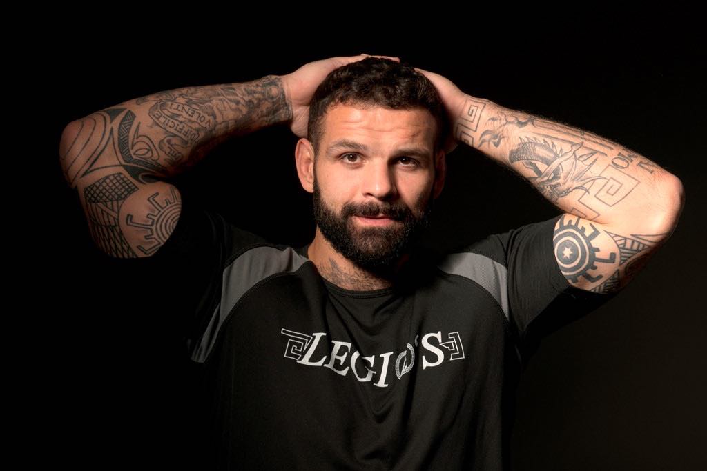 Alessio Sakara’s tattooed arms in a promotional portrait