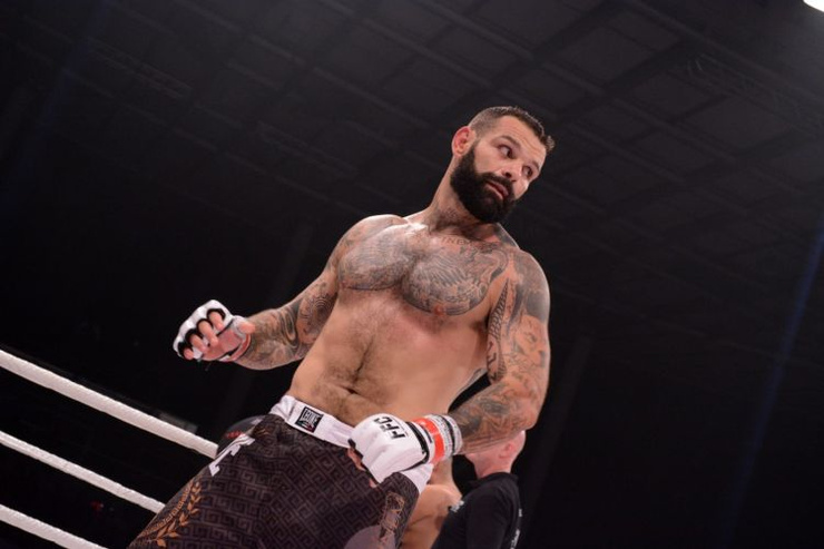 Alessio Sakara fighting with his chest and arm tattoos visible