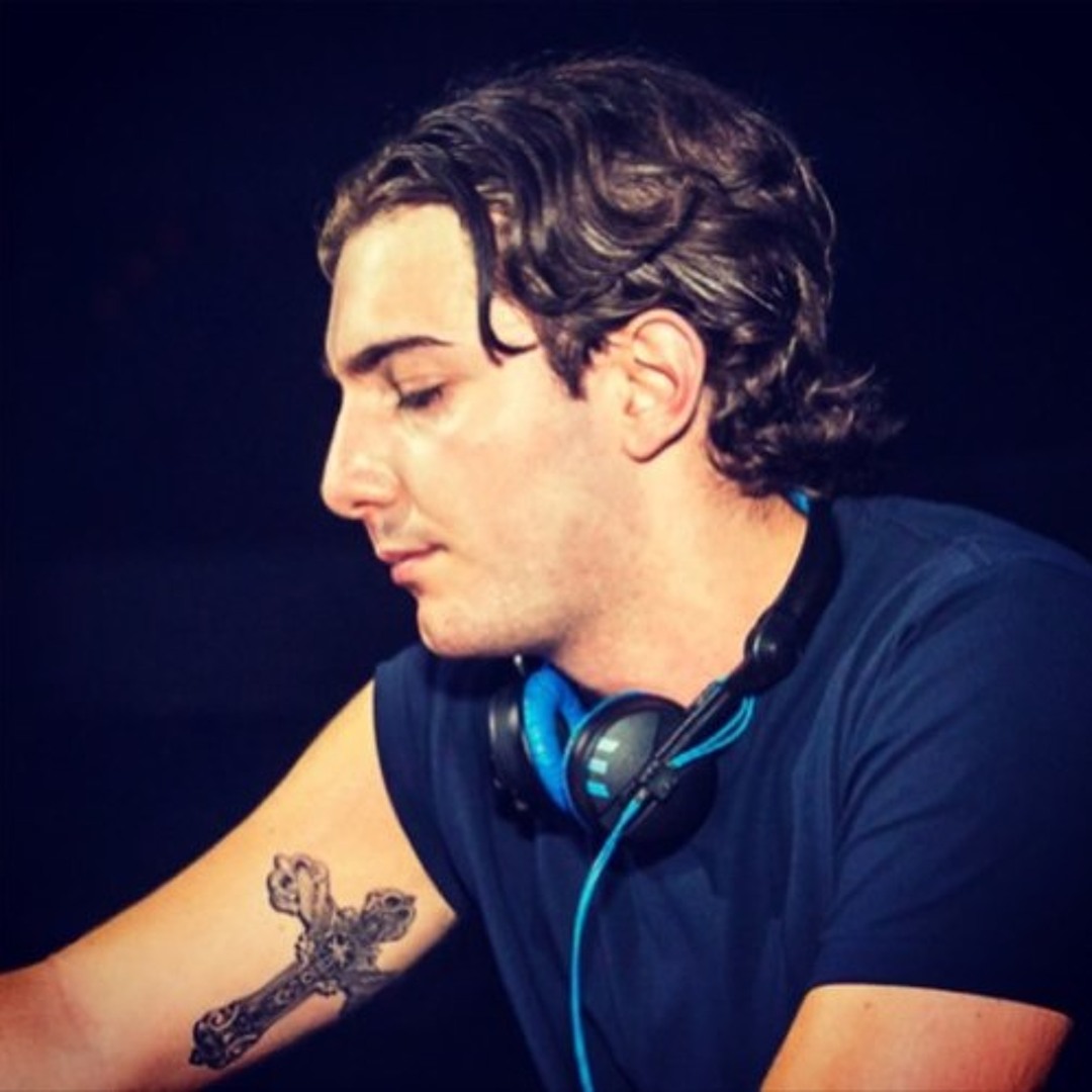 Alesso tattoos: cross tattoo visible on the upper arm during a DJ set