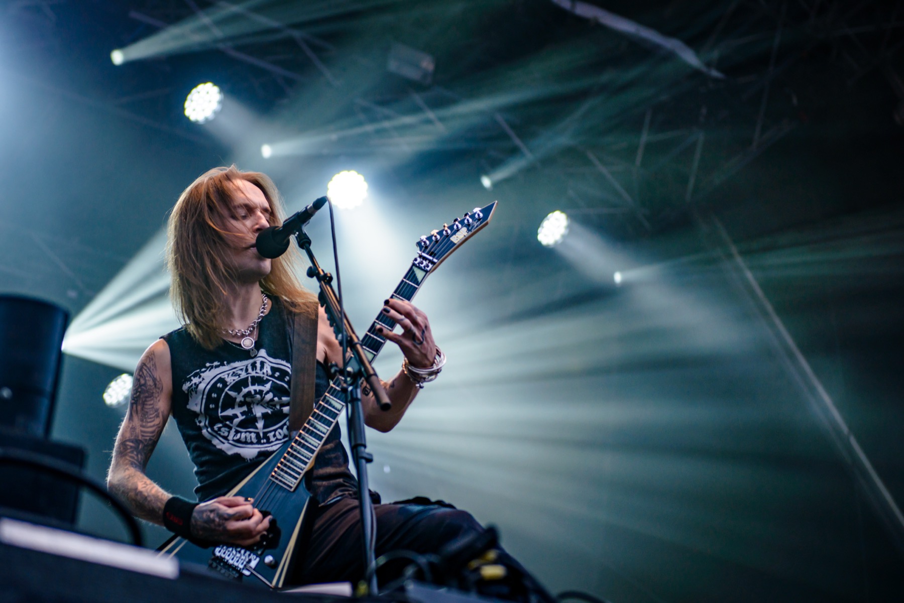 Alexi Laiho showing tattooed arms on stage