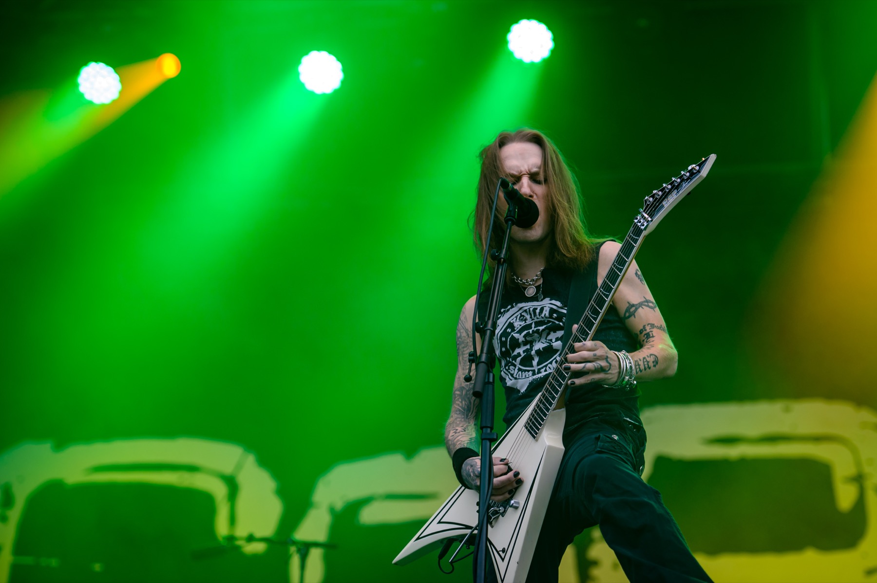 Alexi Laiho's black and grey arm tattoos in a clear stage photo