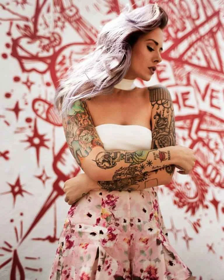Alysha Nett full-color upper-arm and forearm tattoos Alysha Nett tattoos: color portrait showing Alysha Nett's upper-arm and forearm sleeve work, with several separate designs visible at useful size