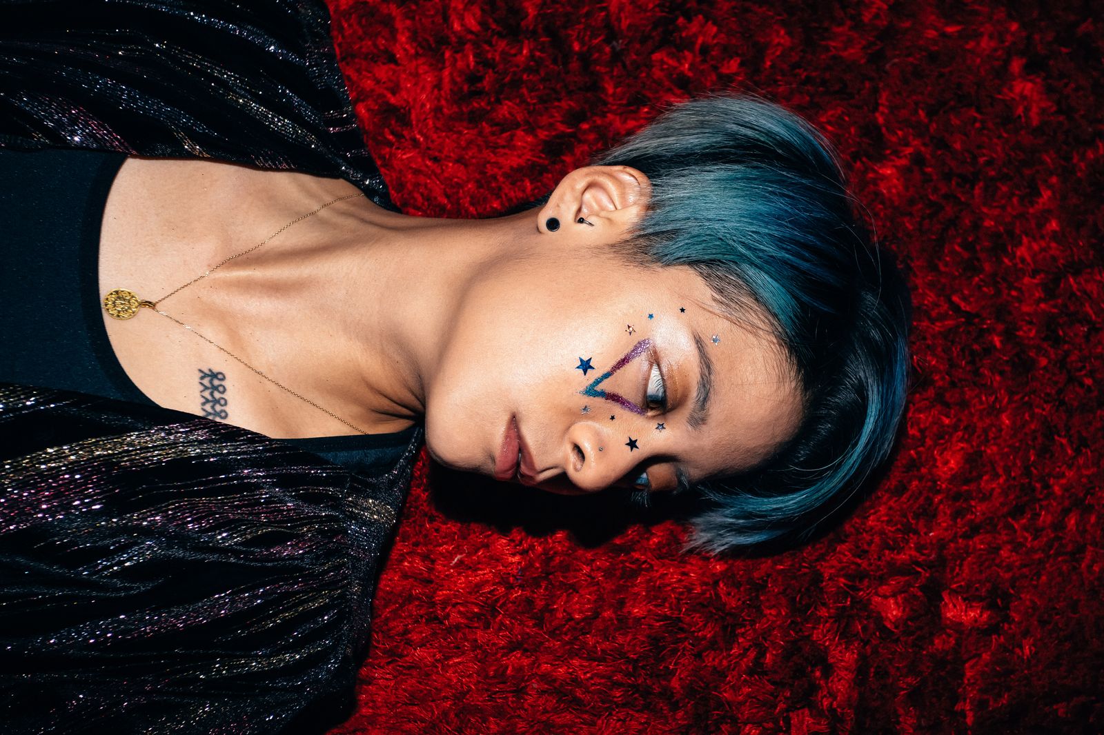 Amber Liu tattoos: right-arm galaxy and palm-tree coverage with visible chest marks