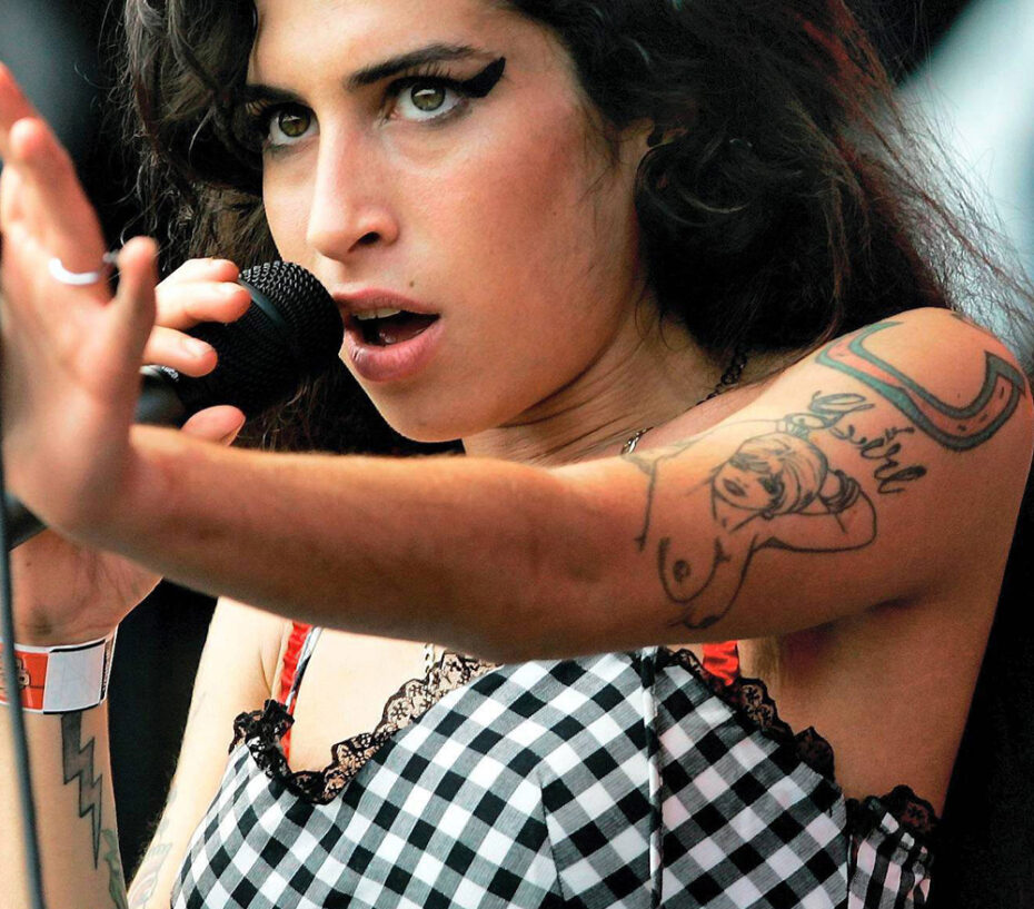 Amy Winehouse pin-up, horseshoe, and arm tattoos