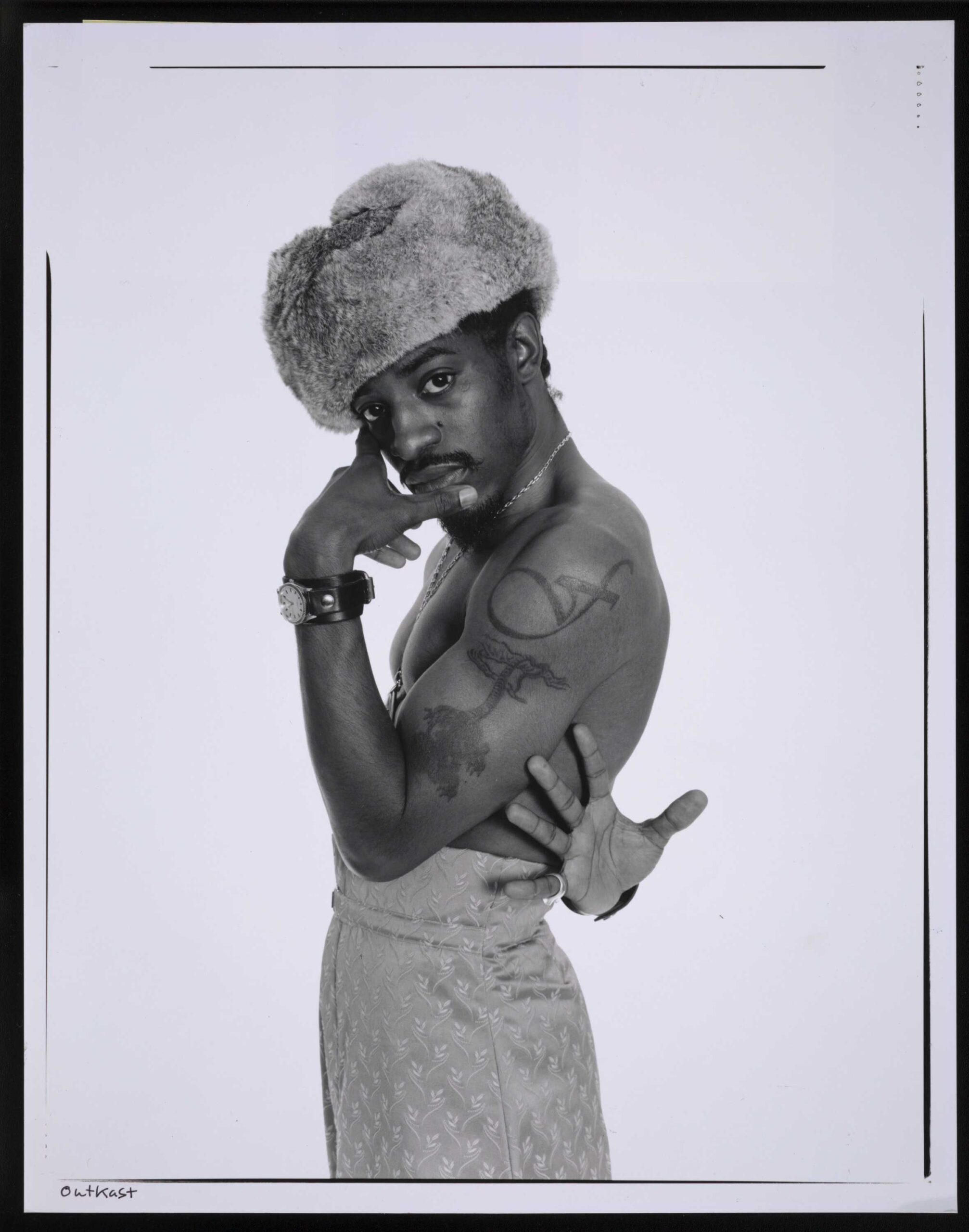André 3000 tattoos: Institutional studio portrait showing the two large tattoos on André's upper arm.