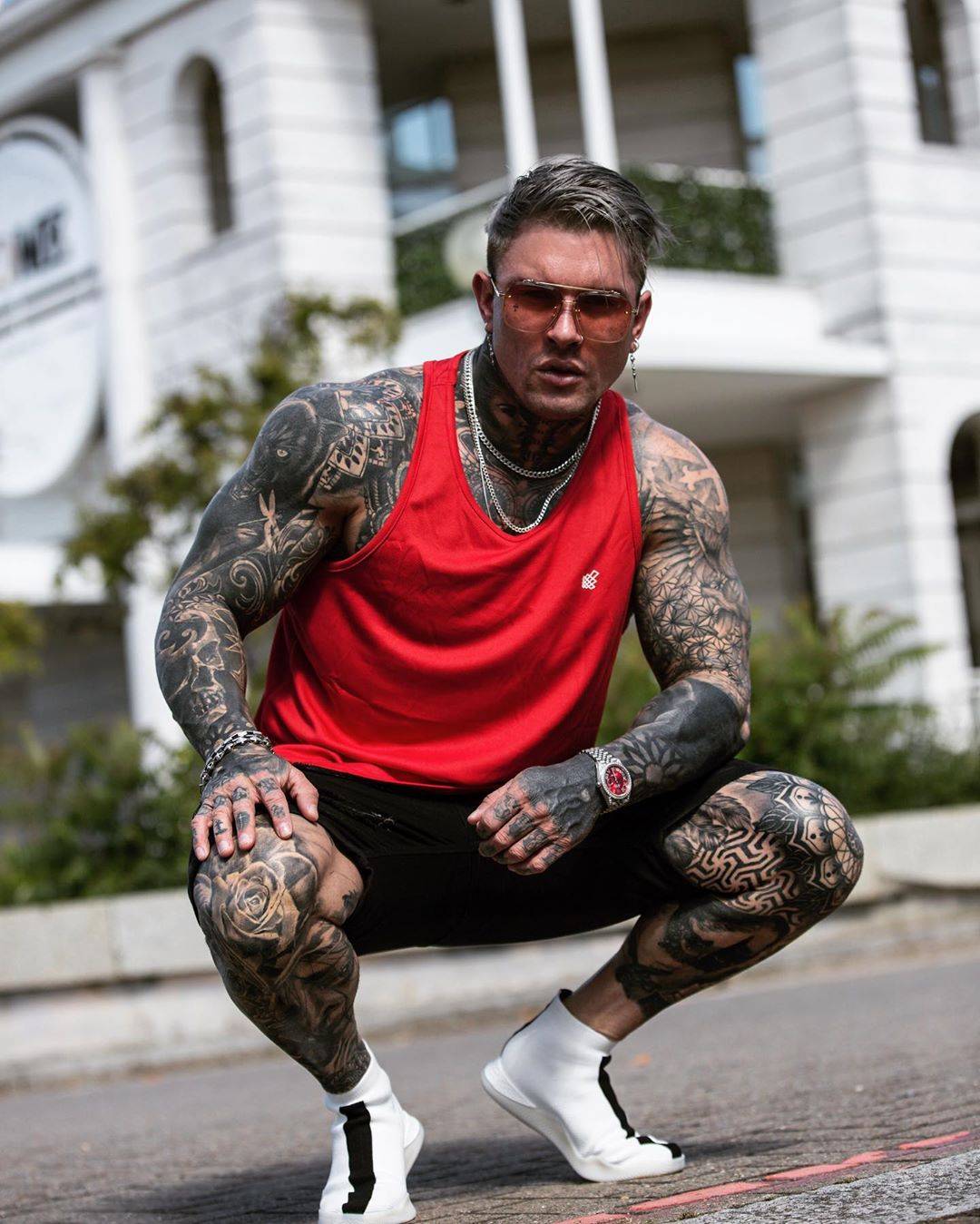 Andrew England tattoos: Right-knee rose and left-knee interlocking geometric patterns