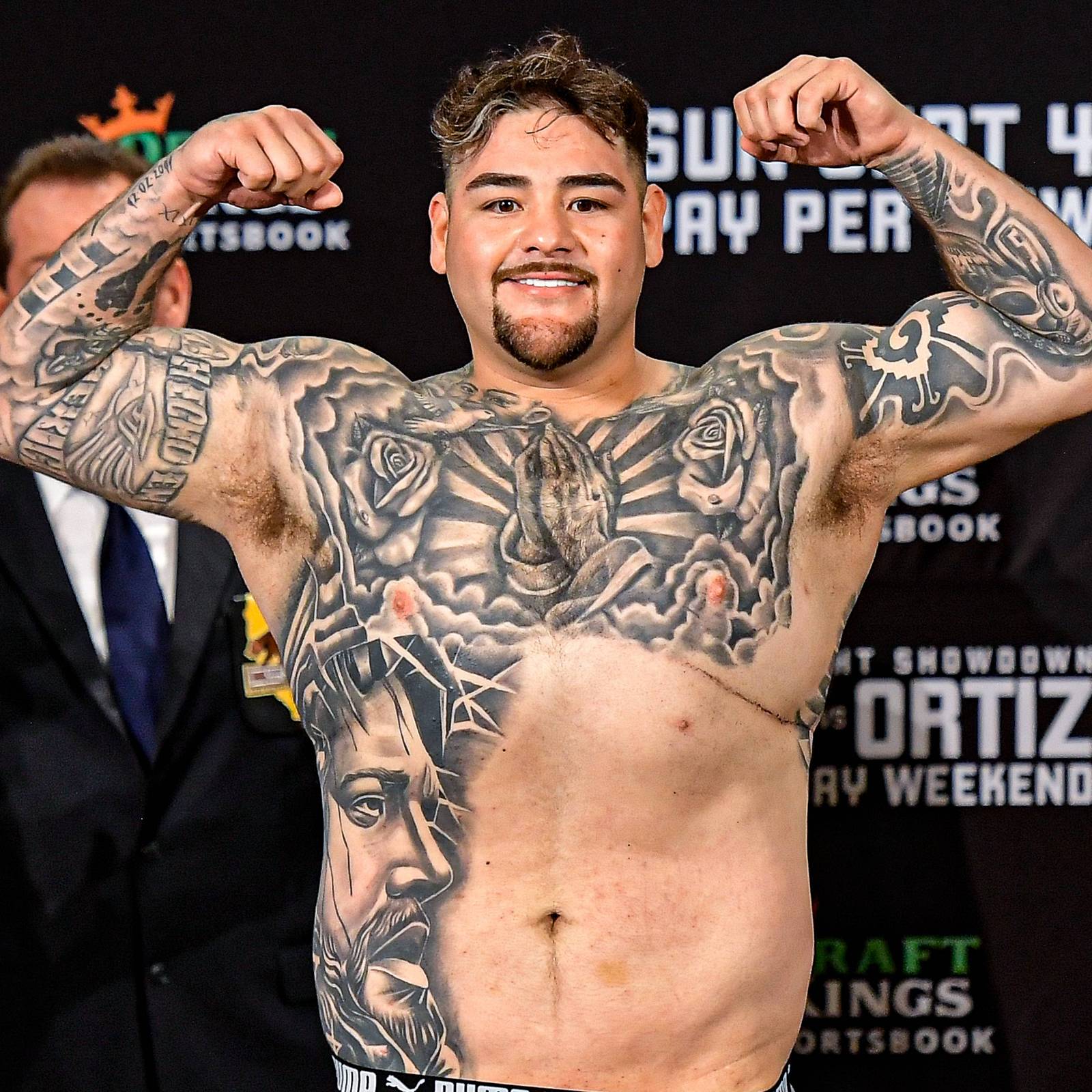 Andy Ruiz Jr. tattoos: full front view showing the chest, both sleeves, side portrait, and large black-and-gray coverage