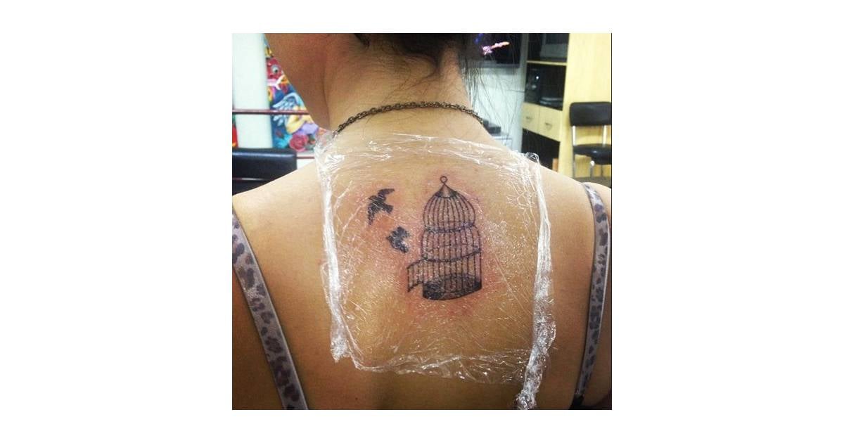 Anitta tattoos: Open cage and flying birds back tattoo