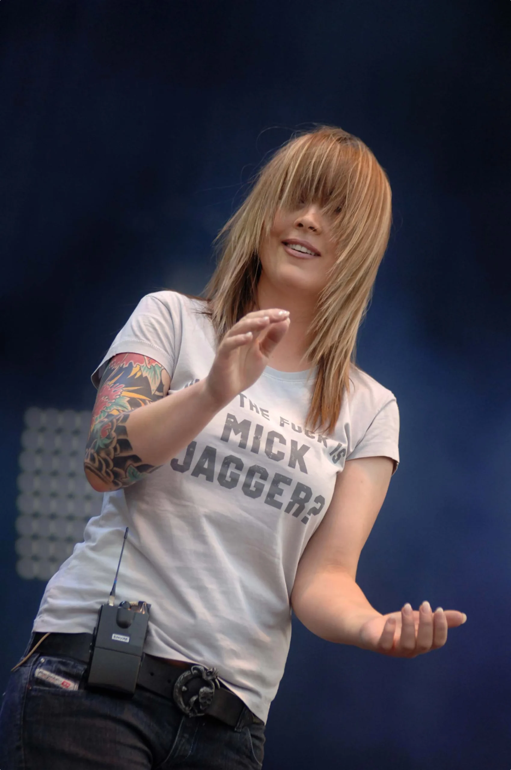 Anouk tattoos: high-resolution performance portrait showing the floral sleeve's repeated flowers, leaves and dark framing